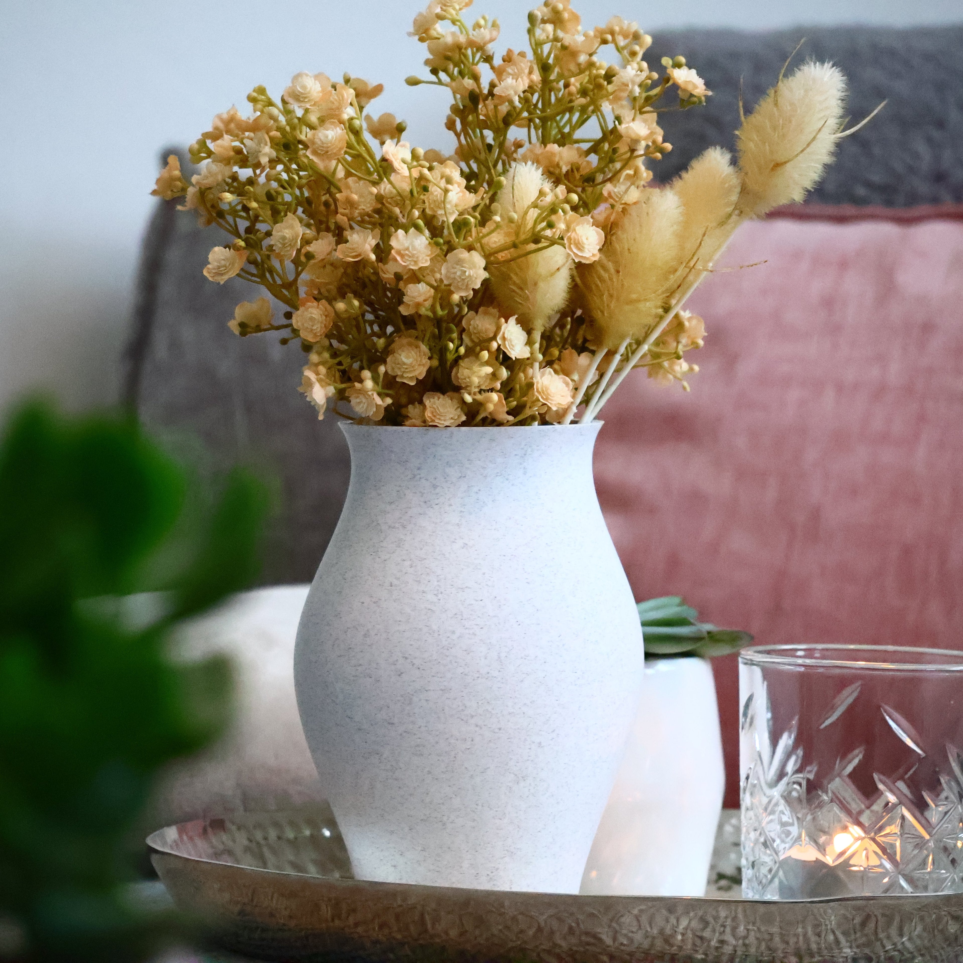 Bild einer Vase auf einem Tisch, eine Lampe in Hintergrund.